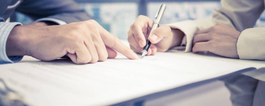Two people signing paper