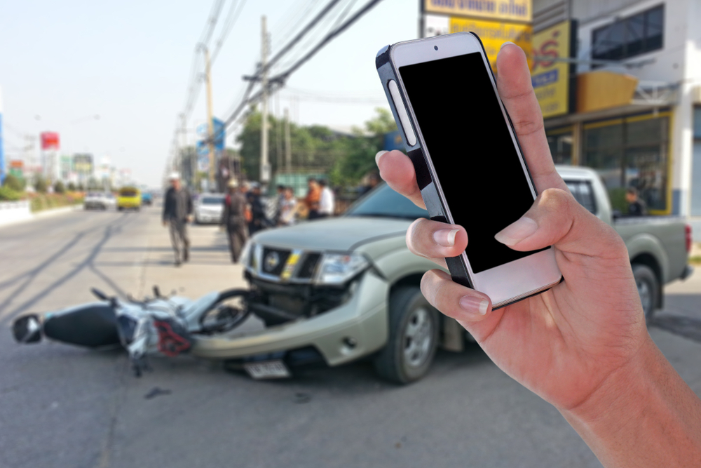 man using smartphone after a car accident to call a personal injury attorney - Ensuring You Get What You Deserve
