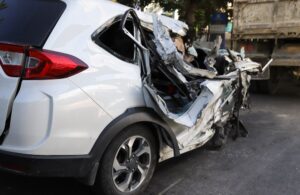 Closeup of right side of damaged smashed white sedan car from road traffic accident. The image for road traffic accident reduction campaign and insurance business.