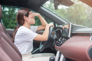 woman feeling stress and angry driving with a suspended license - showing the need of a car accident attorney in New Orleans